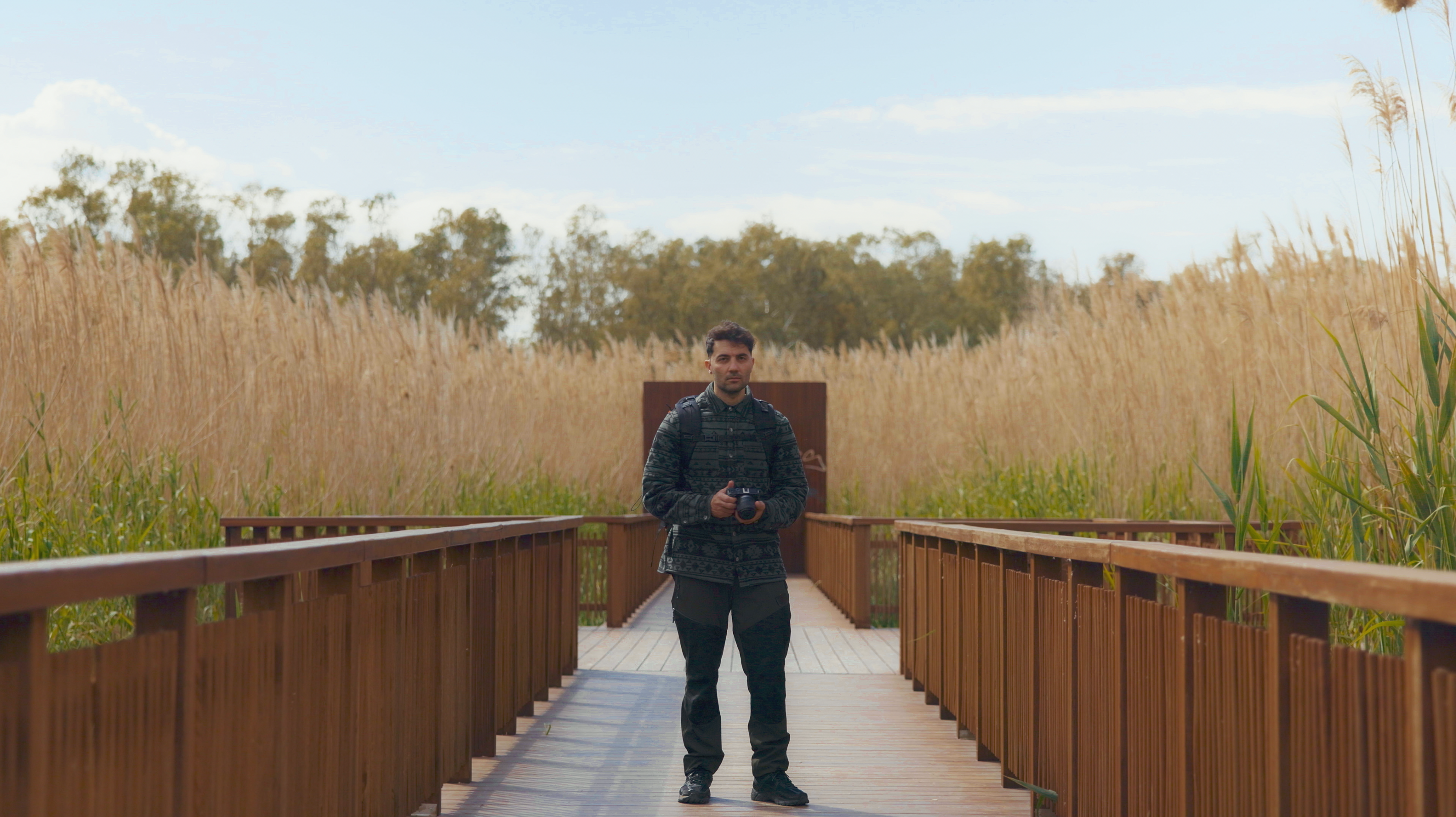 Babis standing on a bridge, camera in hand